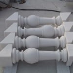 Custom snow white marble building stone balusters with turned profiles and angled ends after fabrication.
