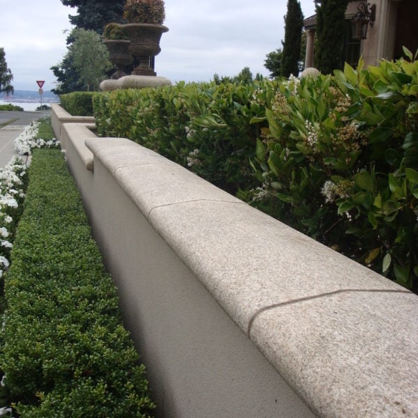 image of Curved and Finished Coping Stone Atop Natural Stone Wall in Landscape Design - HDG Building Materials