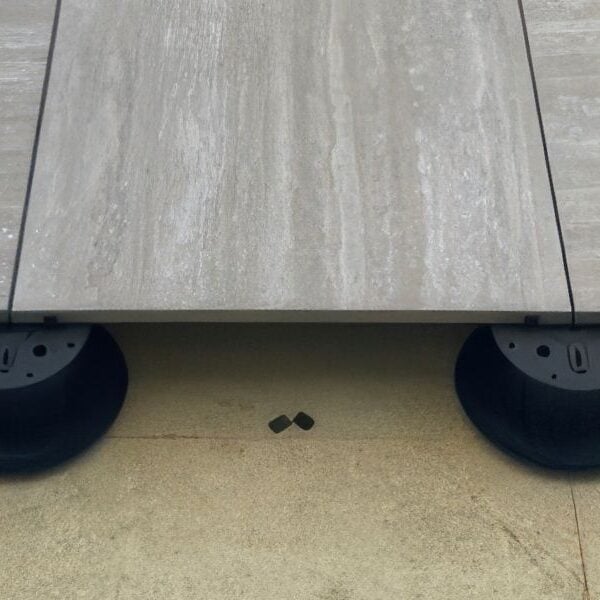 Porcelain paver installation over Buzon adjustable pedestals with substrate showing.