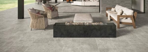 Ardesia Silver 24x24-inch porcelain pavers surround a modern luxury home's outdoor living areas with linear gas fire pit.