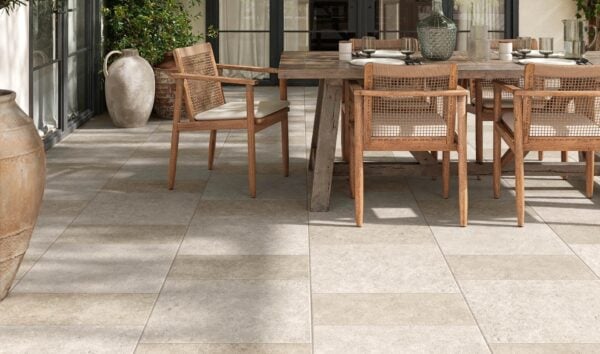 Slate White and Slate Cream 24x24-inch porcelain pavers create a checkerboard pattern beneath a wood pergola with lush greenery and planters.
