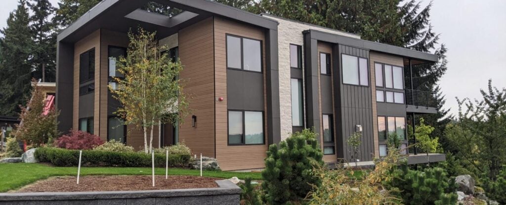 Novano composite siding on a luxury modern home with stone, glass, and metal architectural elements.