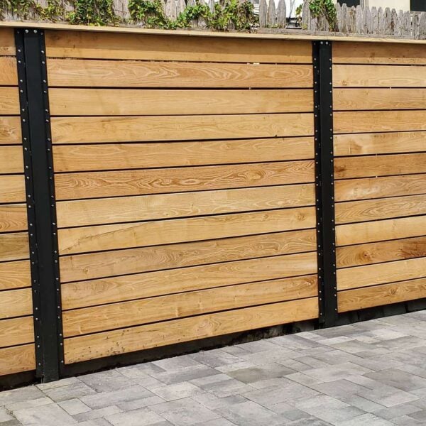 Backyard privacy fence in Brooklyn, New York, built with Black Locust decking boards attached to steel posts.