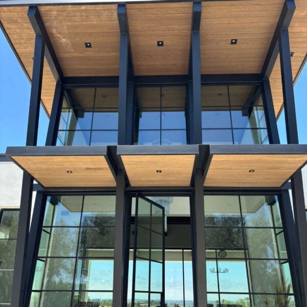 Sassafras 2 × 6 tongue-and-groove wood ceiling with Robi Blend finish, extending from the interior to the exterior of a modern coastal home.